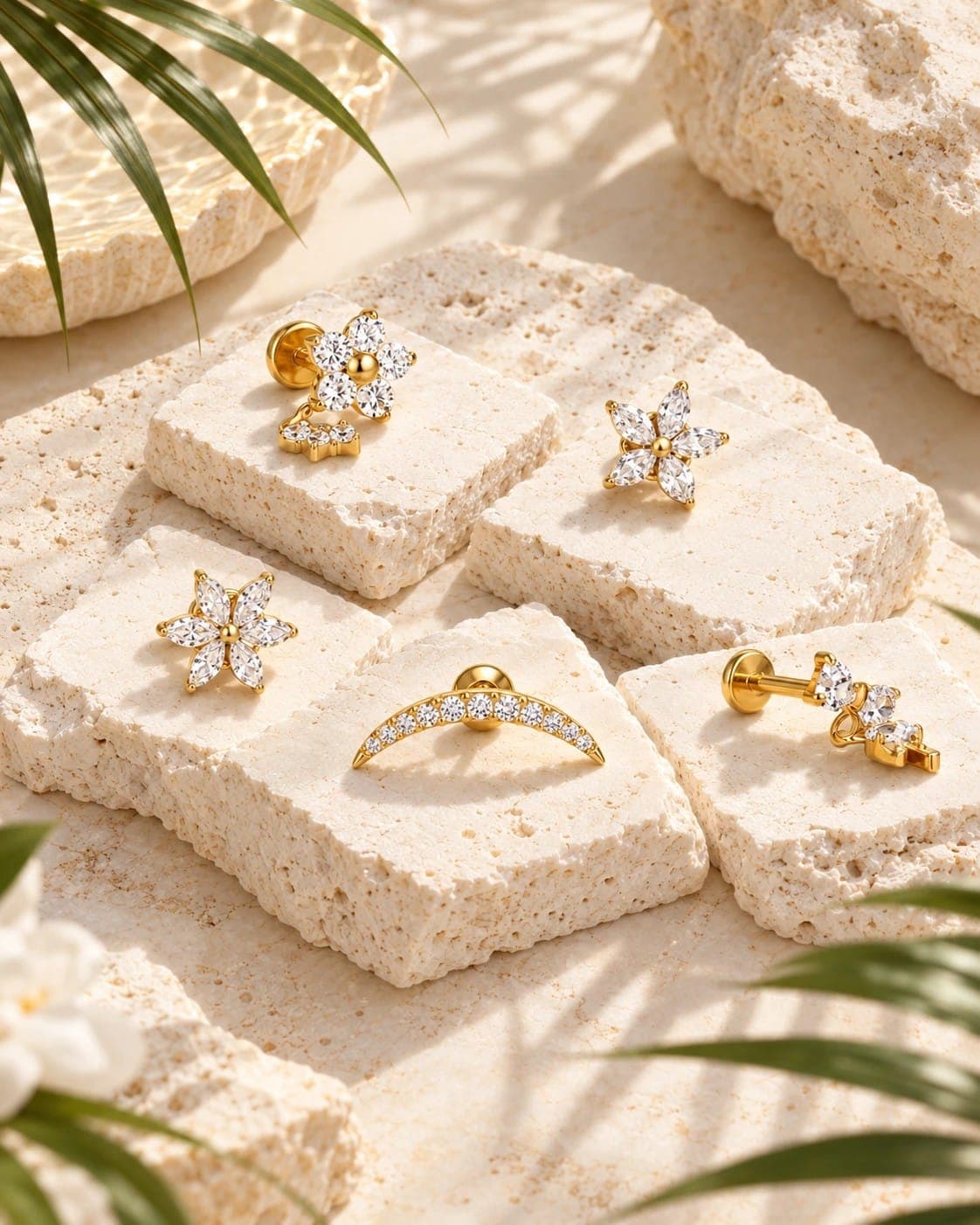 Bijoux d'oreille dorés en forme de fleurs, sur des pierres claires